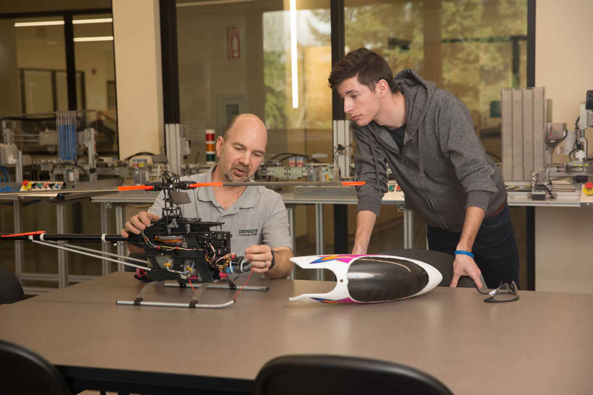 Instructor helping student with robotics project